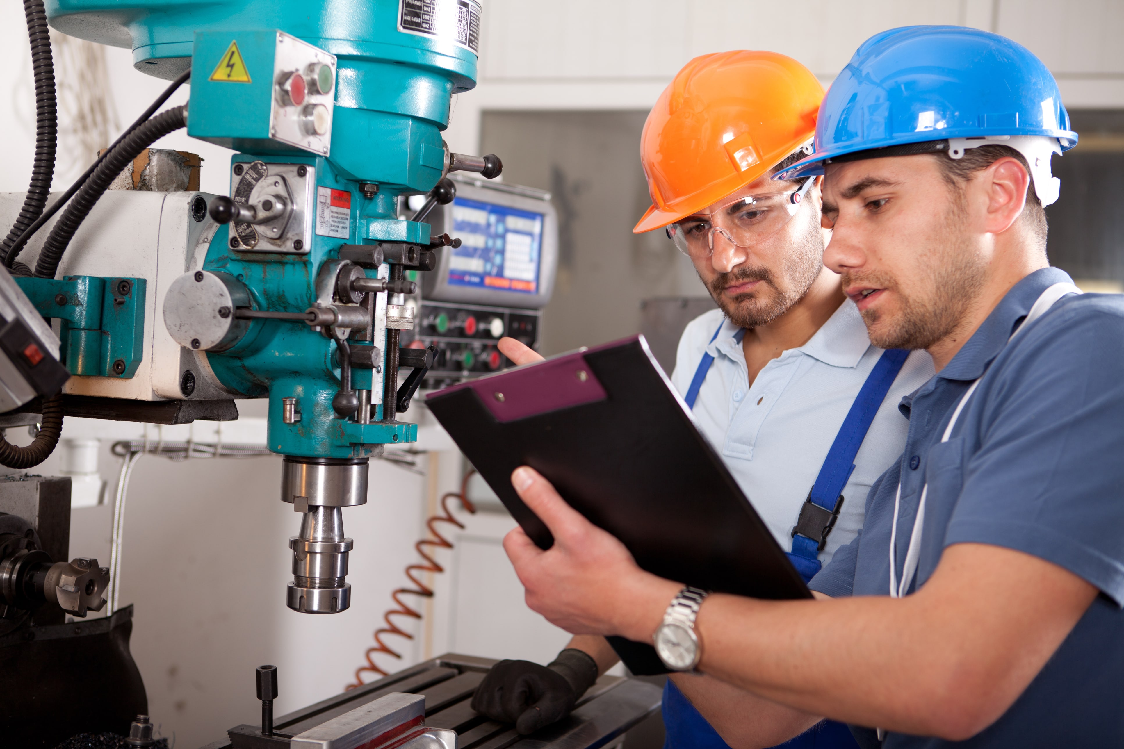 Men work on drill press