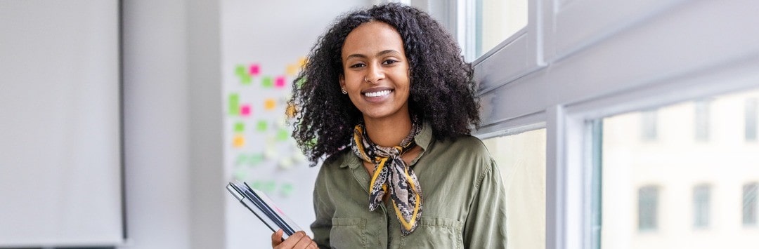 Smiling woman holding a notebook
